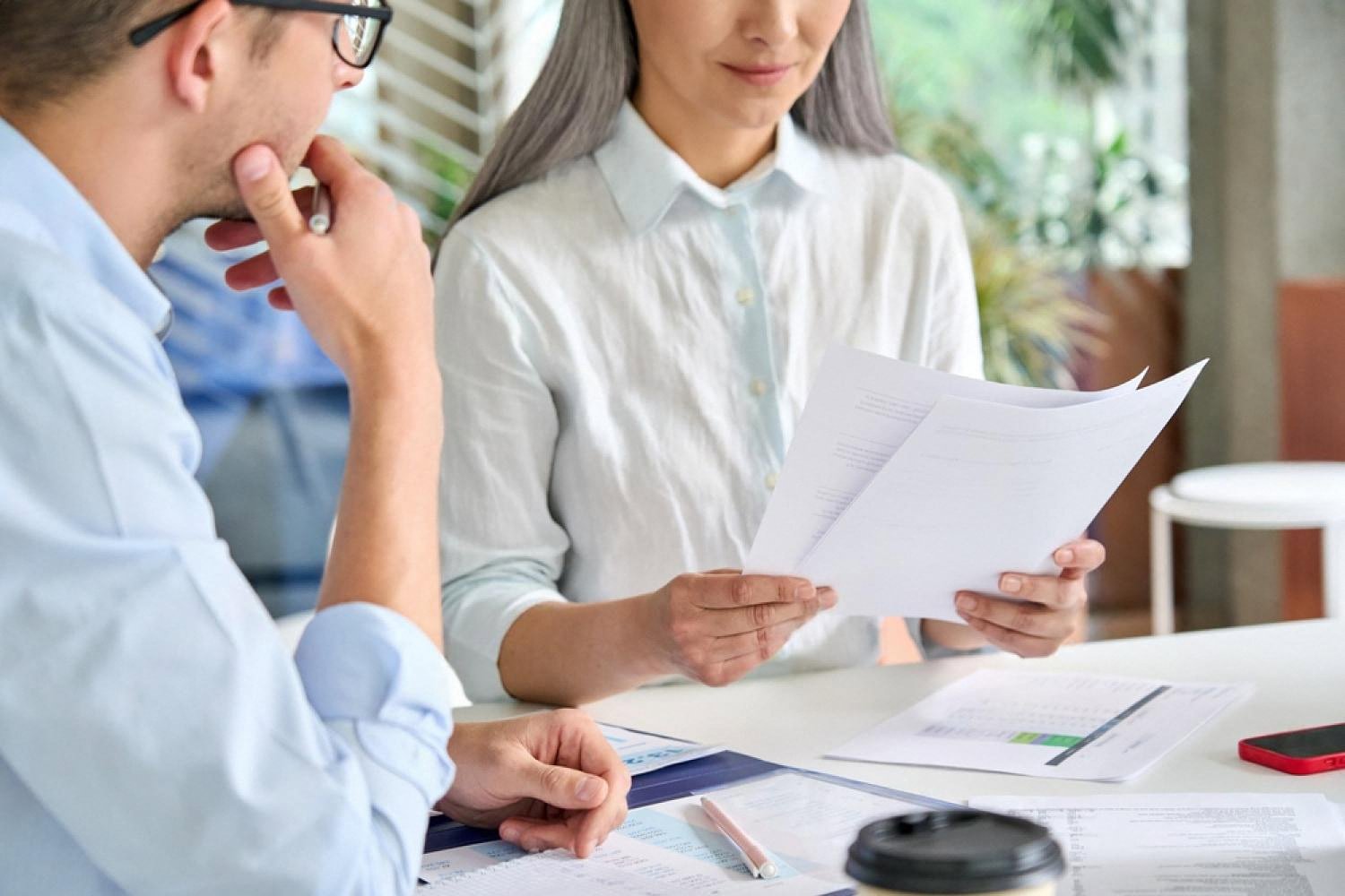 HR manager and colleague reviewing employee assessment reports in a UAE office